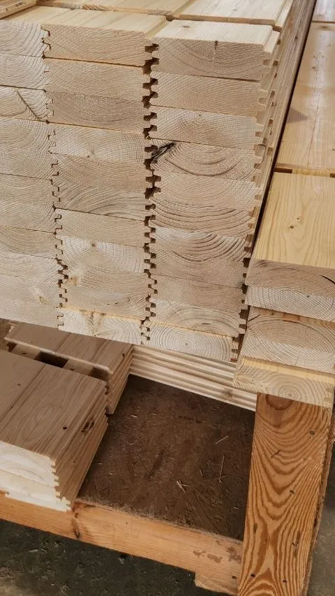 Tongue-and-groove logs stacked end on, showing the tongue and groove of the profile