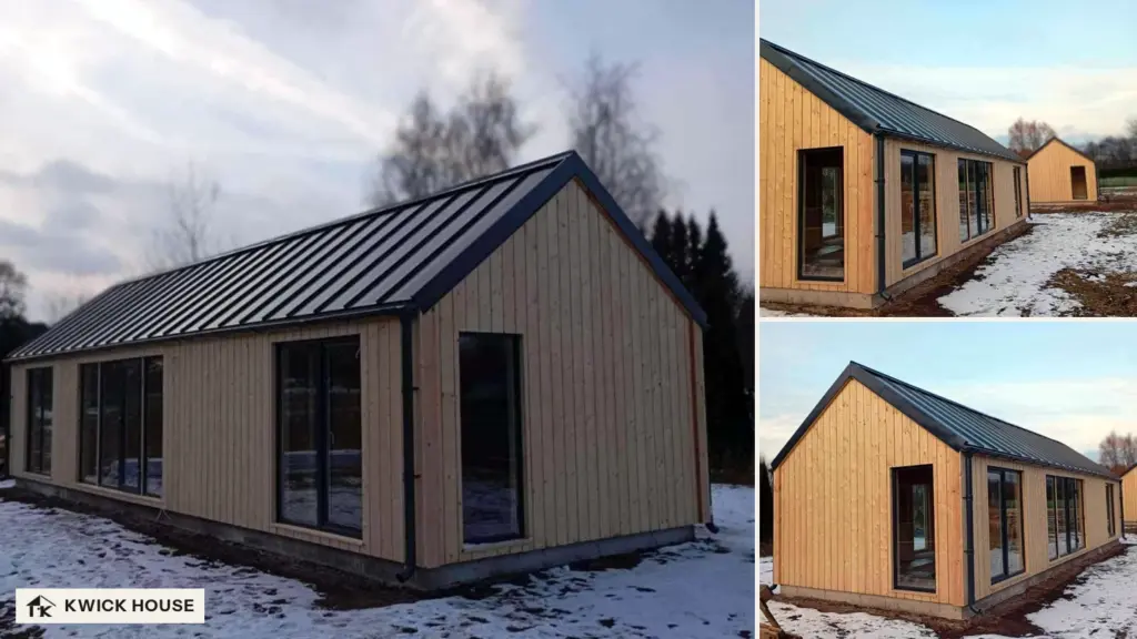 Long barn-style log cabin with vertical cladding, a dark metal roof and large dark-framed windows, in winter snow