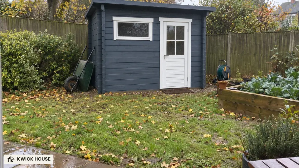 Summer House 3m x 2m, 5 m², painted dark blue-grey, at the end of a small garden in autumn